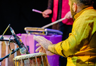 Artists bursaries available. Live music capture image with tabla and drums.