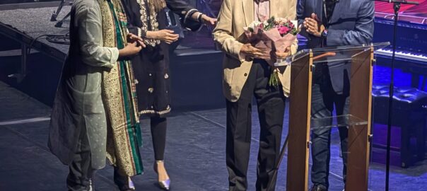 Jaswinder Singh, Asian Arts Agency director on stage with members of Zakir Hussain's family